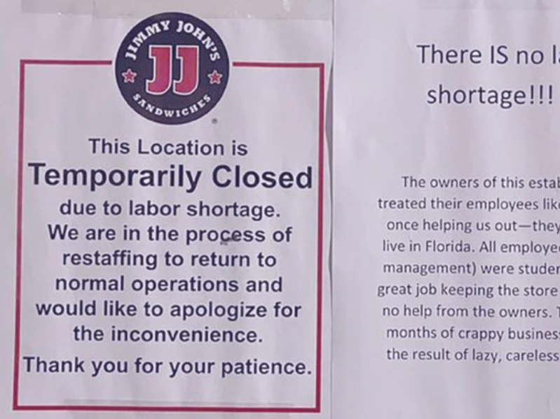 A close up of two signs that were posted in front of a Jimmy John's restaurant. One sign is announcing the closure due to a "labor shortage" while the second sign is a note from previous employees discussing their negative experiences working there.