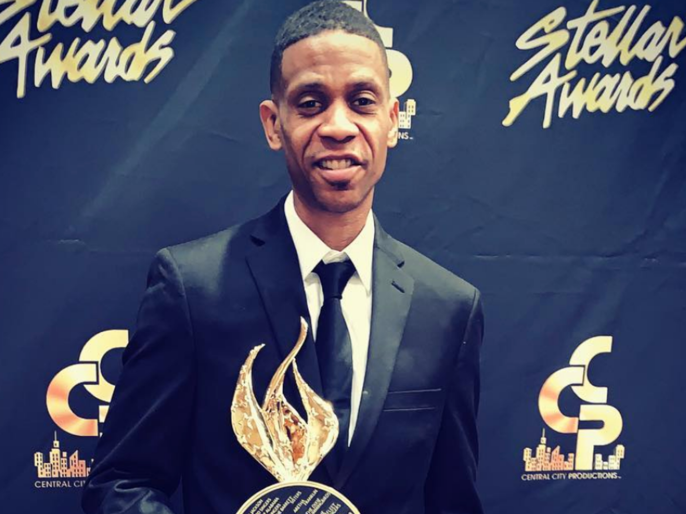 Kecalf Cunningham standing with an award