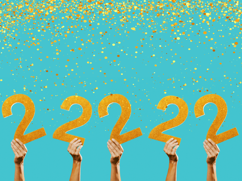 Hands holding up large, golden "2s" with blue background and gold glitter