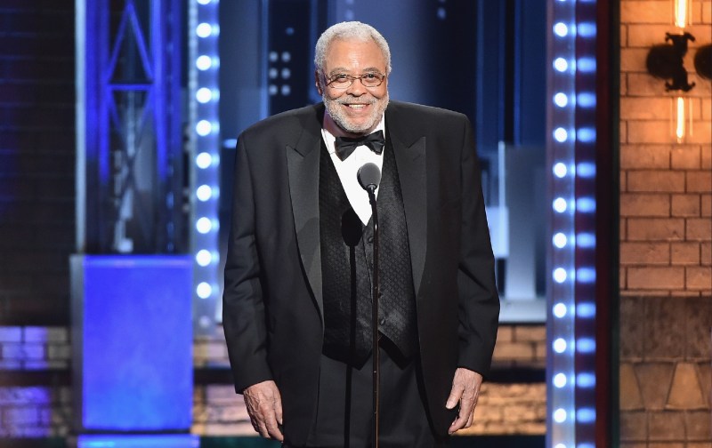 James Earl Jones smiles and wears a black tux as he makes remarks onstage