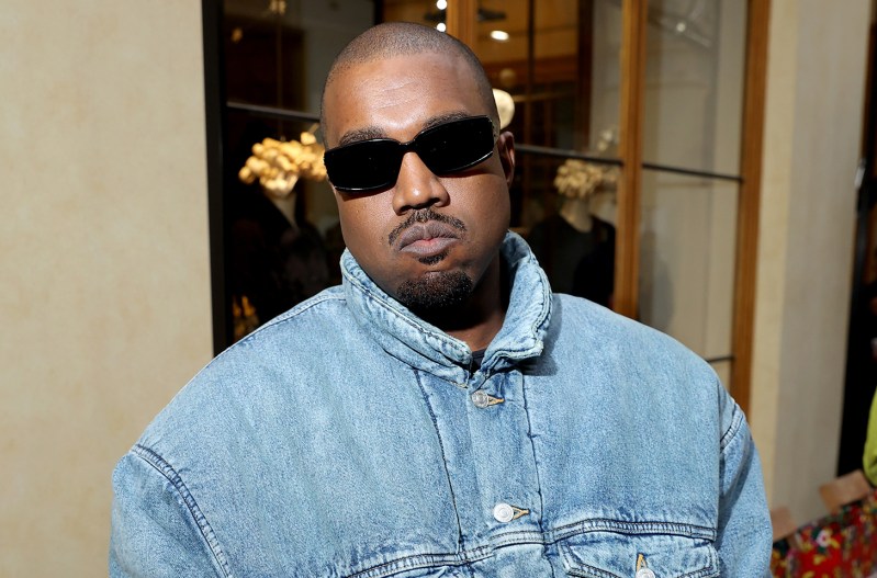 Kanye West looking serious in sunglass and a denim shirt