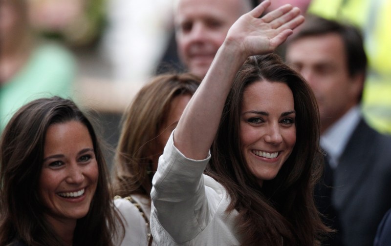 Pippa Middleton (left) smiles as sister Kate (right) waves to a gathered crowd ahead of her wedding