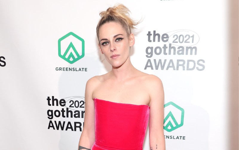 Kristen Stewart wears a strapless pink dress against a white background on the red carpet