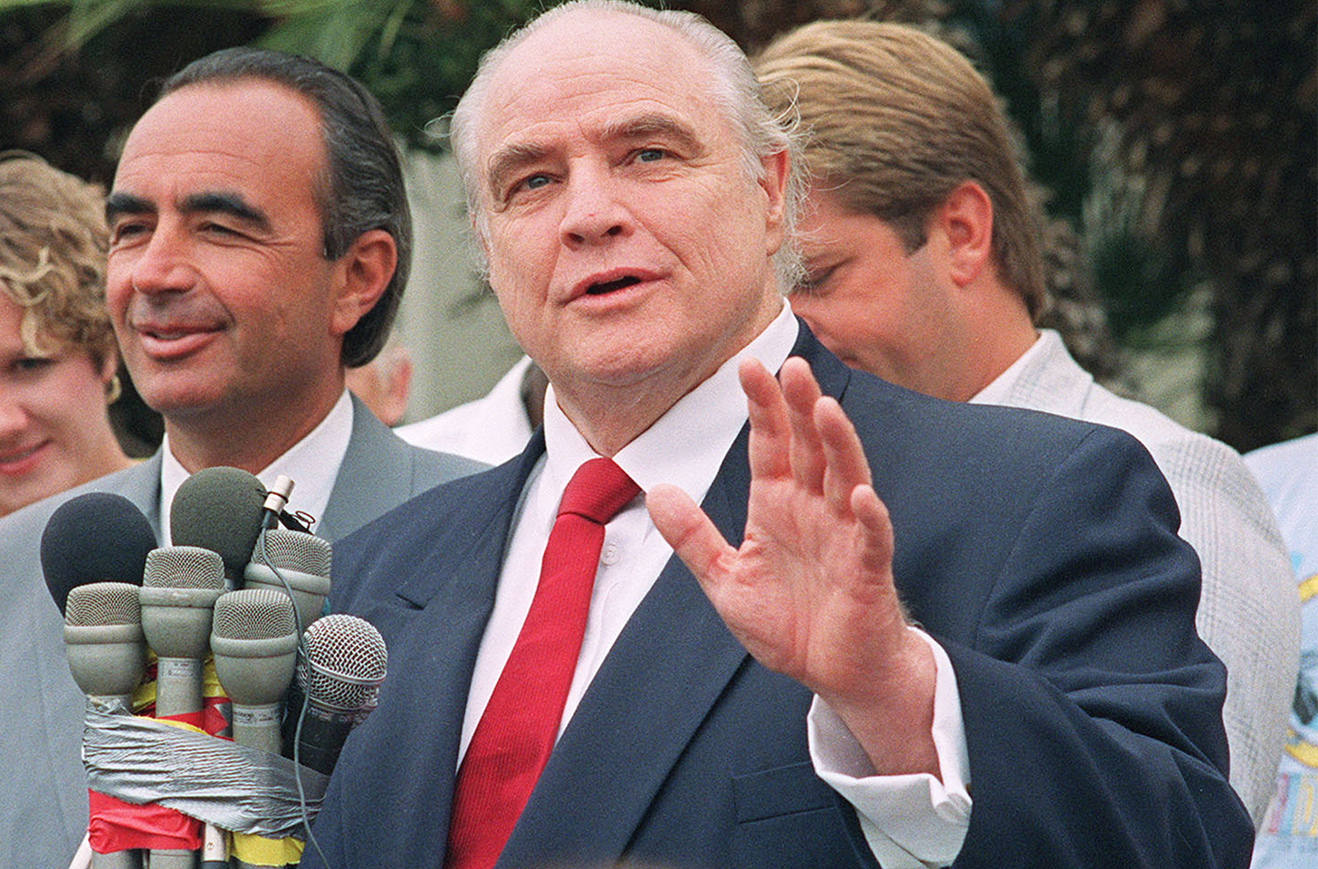 Marlon Brando in a suit speaking into a microphone band