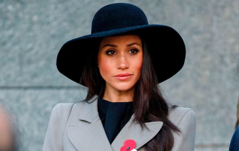 Meghan Markle wears a gray coat and a black hat during a royal event