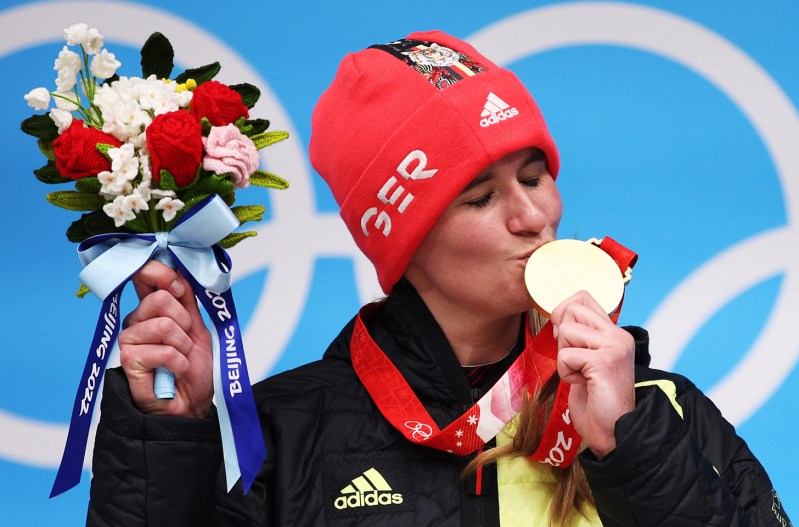 Natalie Geisenberger of Germany on the top podium, kissing her gold medal at the 2022 games in Beijing