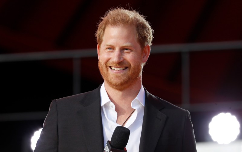 Prince Harry wears a dark suit jacket as he makes remarks onstage
