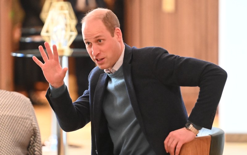 Prince William wears a sweater and blazer during a royal outing