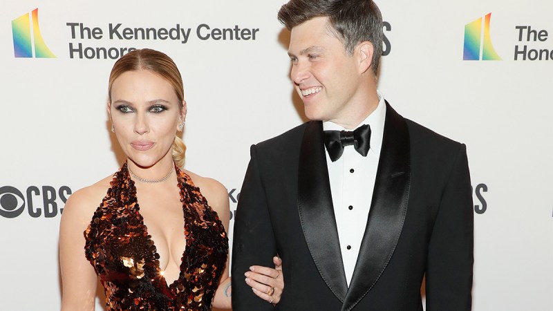 Scarlett Johansson on the left, Colin Jost looking at her and smiling on the right.