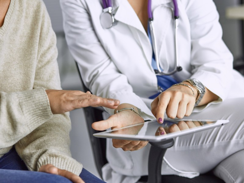 female doctor talking to a patient on a tablet