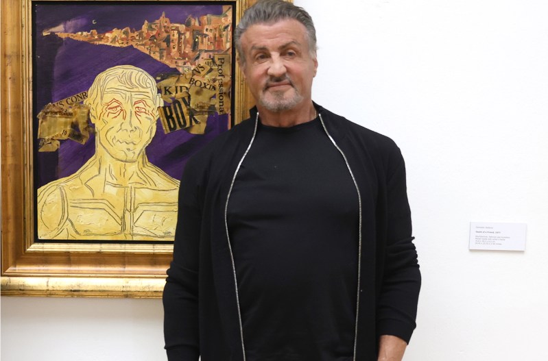 Sylvester Stallone standing in front of his painting, "Rocky"