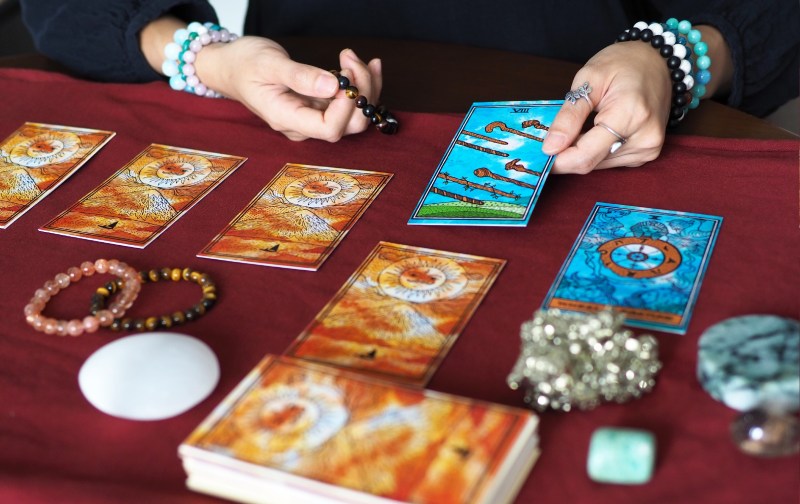 Hands hold a tarot card during a reading