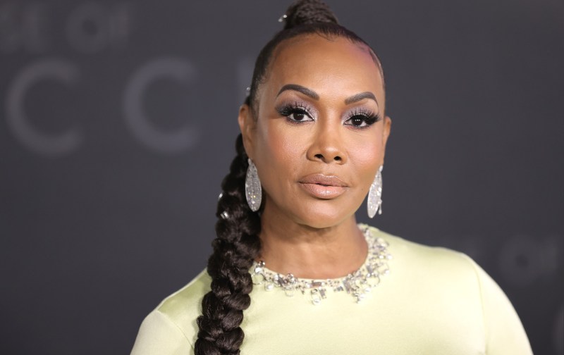 Vivica A. Fox wears an off white dress against a black background on the red carpet