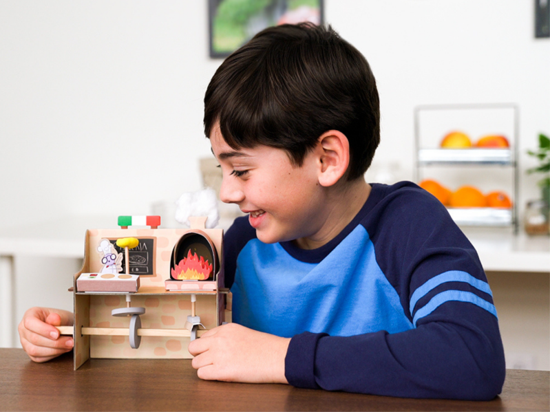 Boy playing with model kitchen activity