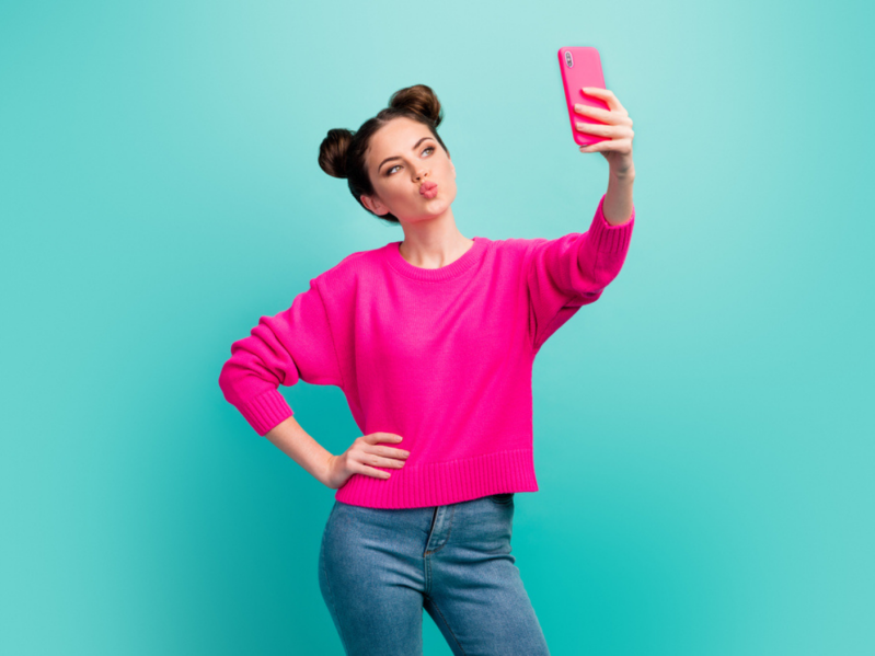 Woman making pouty face at phone taking selfie