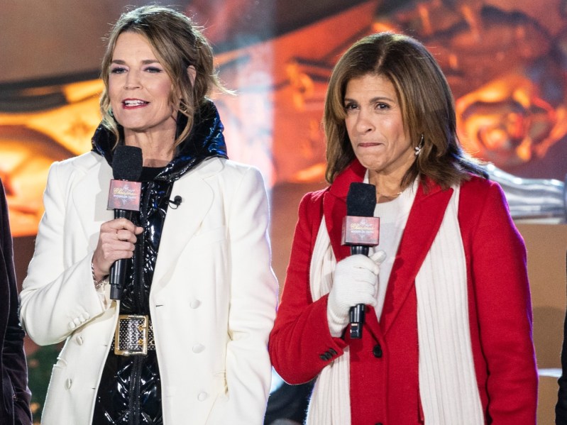 Savannah Guthrie (L) and Hoda Kitb (R) wearing winter coats and holding microphones