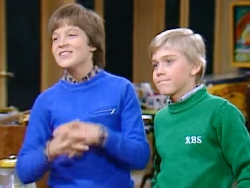 Young Jason Bateman wearing blue shirt standing next to young Ricky Shroder wearing green shirt