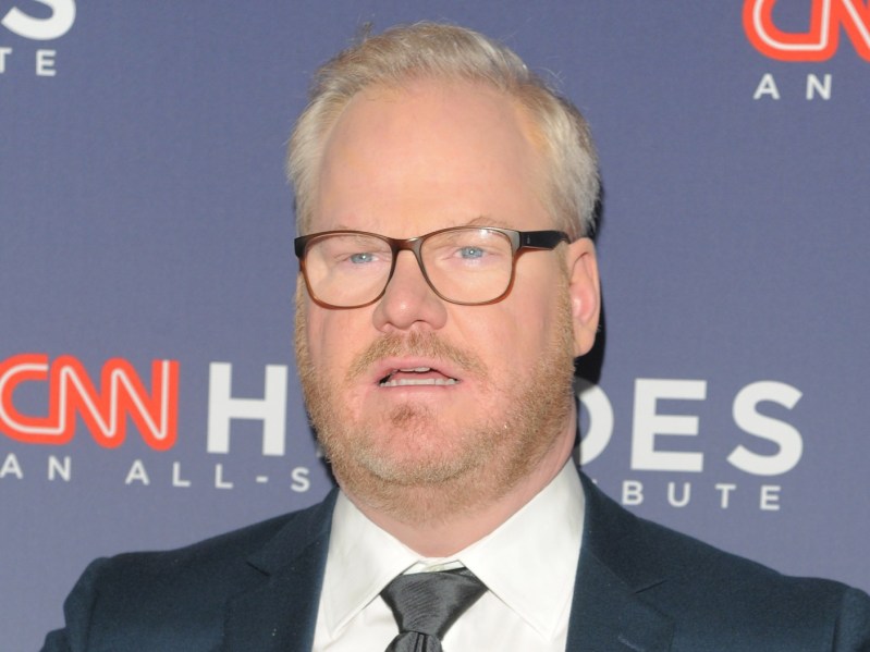 Jim Gaffigan with mouth open wearing suit and tie
