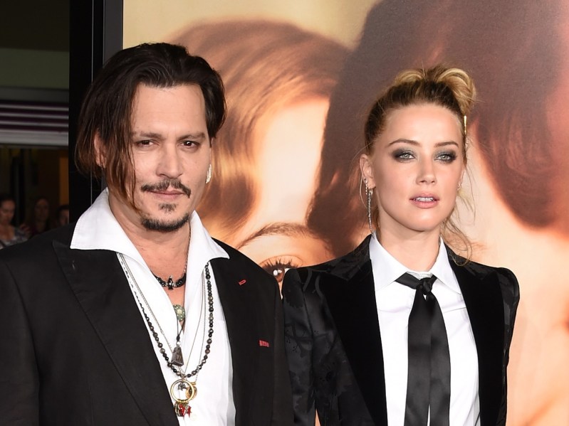 Johnny Depp (L) wearing black blazer, Amber Heard (R) wearing black suit and tie