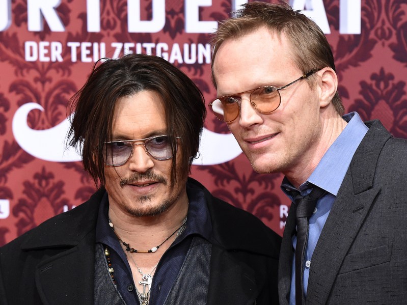 Johnny Depp in sunglasses standing with Paul Bettany