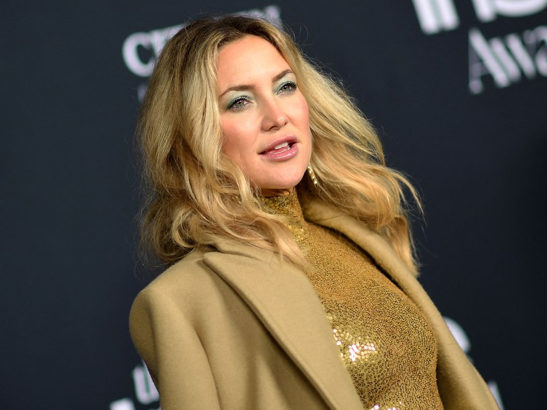 Kate Hudson in a sparkly gold dress and gold blazer