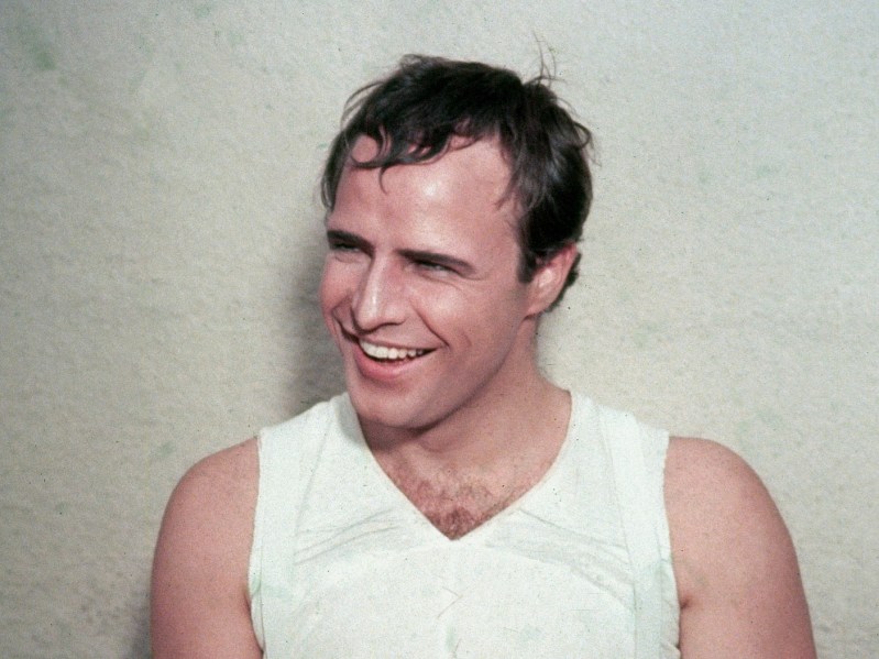 A young Marlon Brando smiles in a white tank top
