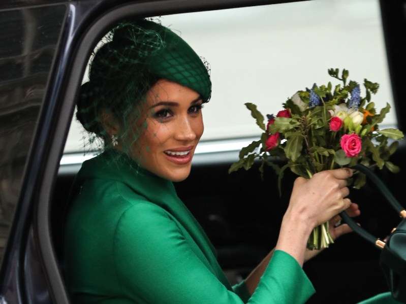 Meghan Markle wears a green hat and dress as she enters a car after a royal event