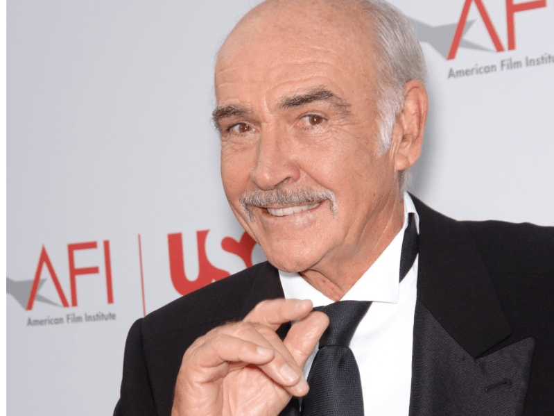 Sean Connery adjusts tie and smiles