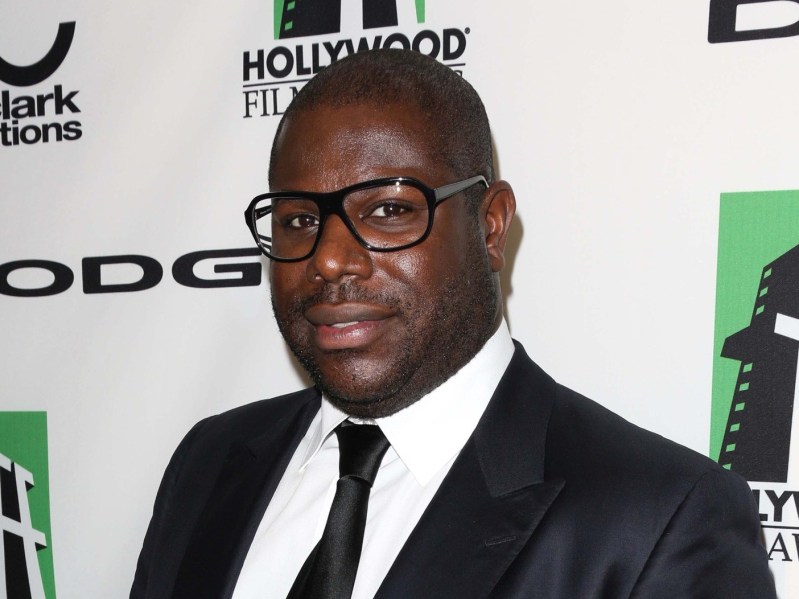 Steve McQueen wearing black suit and tie