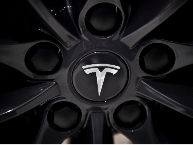 Closeup of black Tesla wheel with logo in the middle