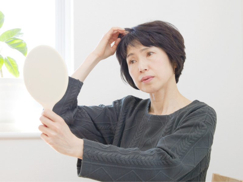 Concerned woman looks at scalp