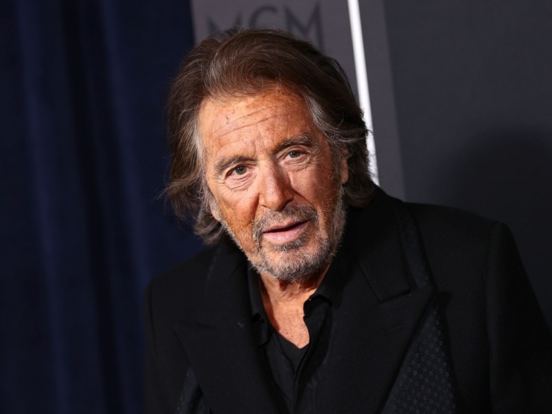 Al Pacino looking into the camera wearing all black on a black backdrop