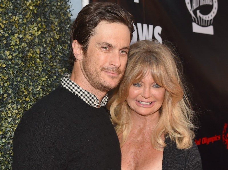 Oliver Hudson and his mother Goldie Hawn, both wearing black, pose together on the red carpet