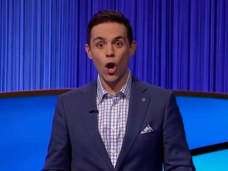Mike Janela wears a dark blue suit on the set of Jeopardy