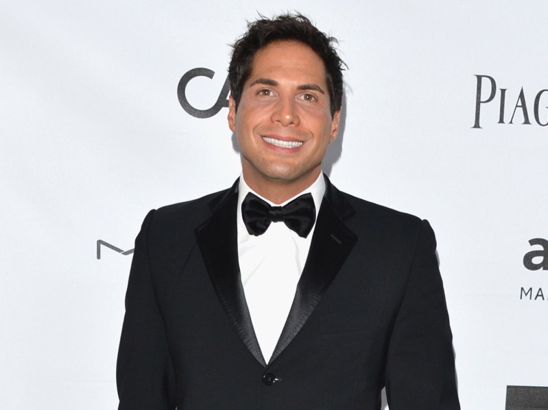 Joe Francis smiling wearing black suit jacket and black bowtie