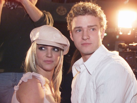 Britney Spears (L) in pale pink hat and Justin Timberlake (R) in white button-down