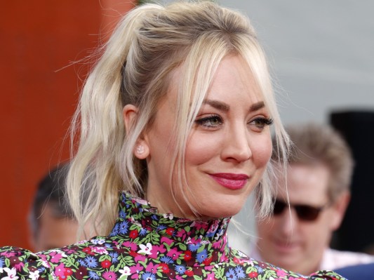 Closeup of Kaley Cuoco with ponytail and floral top