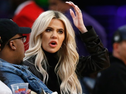 Khloe Kardashian wears a black top while sitting court side at a basketball game