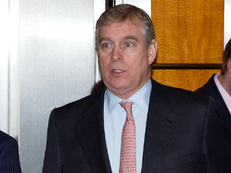 Prince Andrew wears a black suit indoors