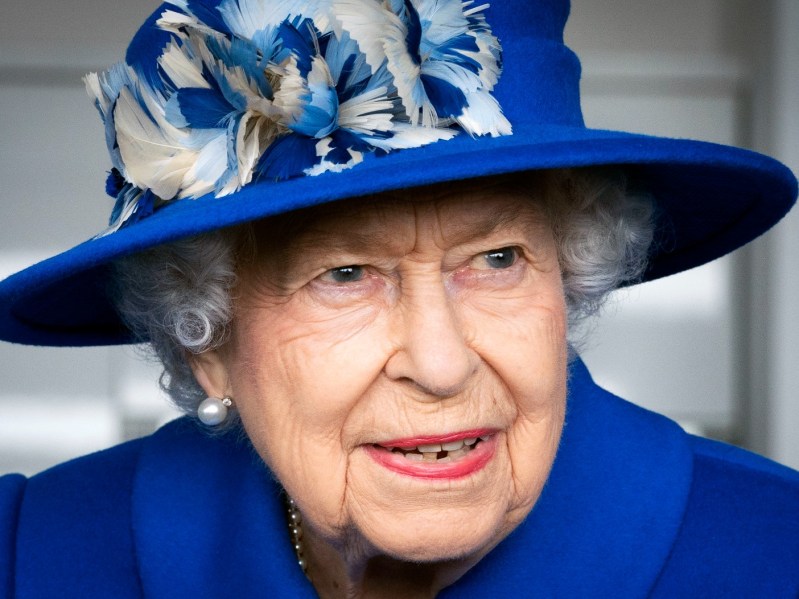 Closeup of Queen Elizabeth wearing royal blue suit jacket and hat