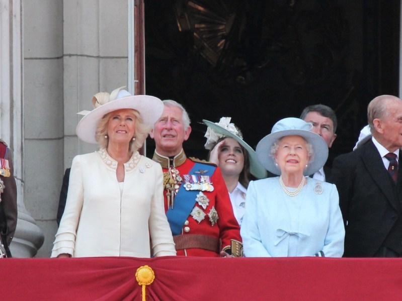 Camilla Parker Bowles, Prince Charles, and Queen Elizabeth standing on balcony