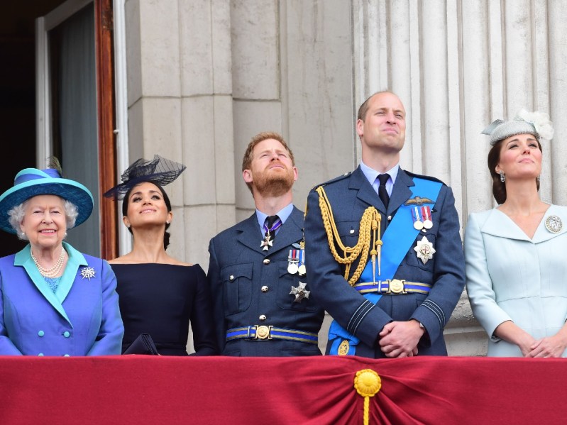 Queen Elizabeth, Meghan Markle, Kate Middleton, and other members of the royal family stand together on a balcony