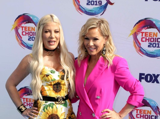 Tori Spelling and Jennie Garth pose in dresses on red carpet