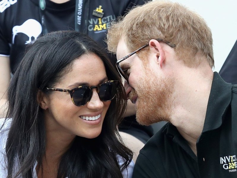 Meghan Markle and Prince Harry in 2017 smiling and wearing sunglasses