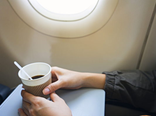 Woman drinking coffee on airplane
