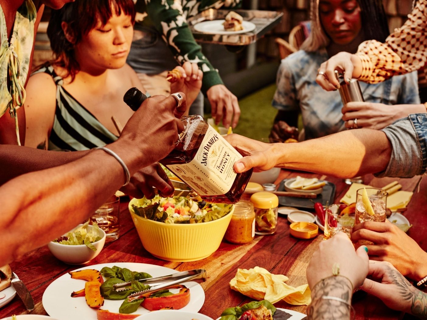 Group of friends at an outdoor BBQ enjoying Jack Daniel's Flavored Whiskey drinks.