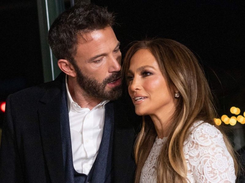 close up of Ben Affleck in a suit and Jennifer Lopez in a white dress