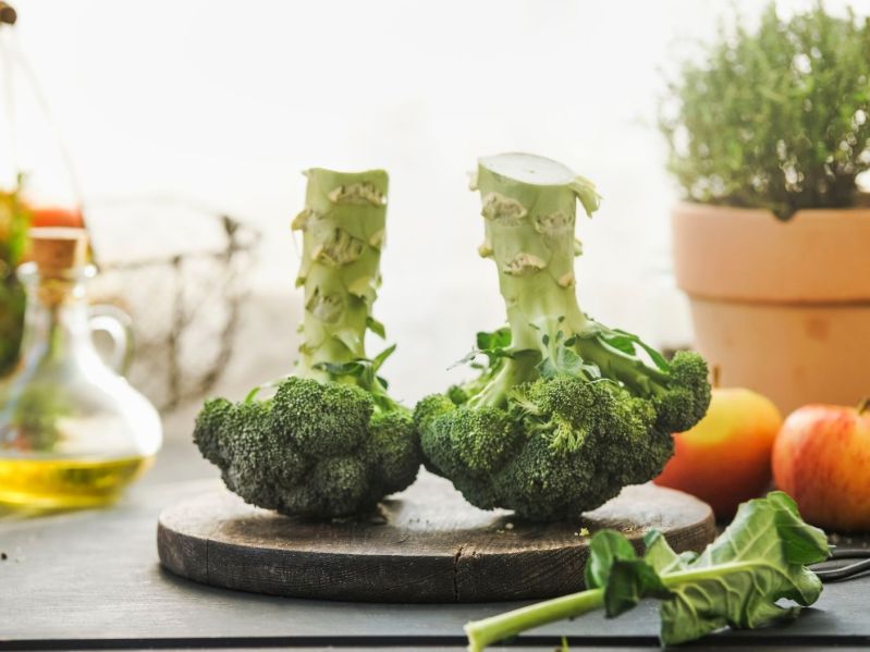 Two heads of broccoli on a cutting board