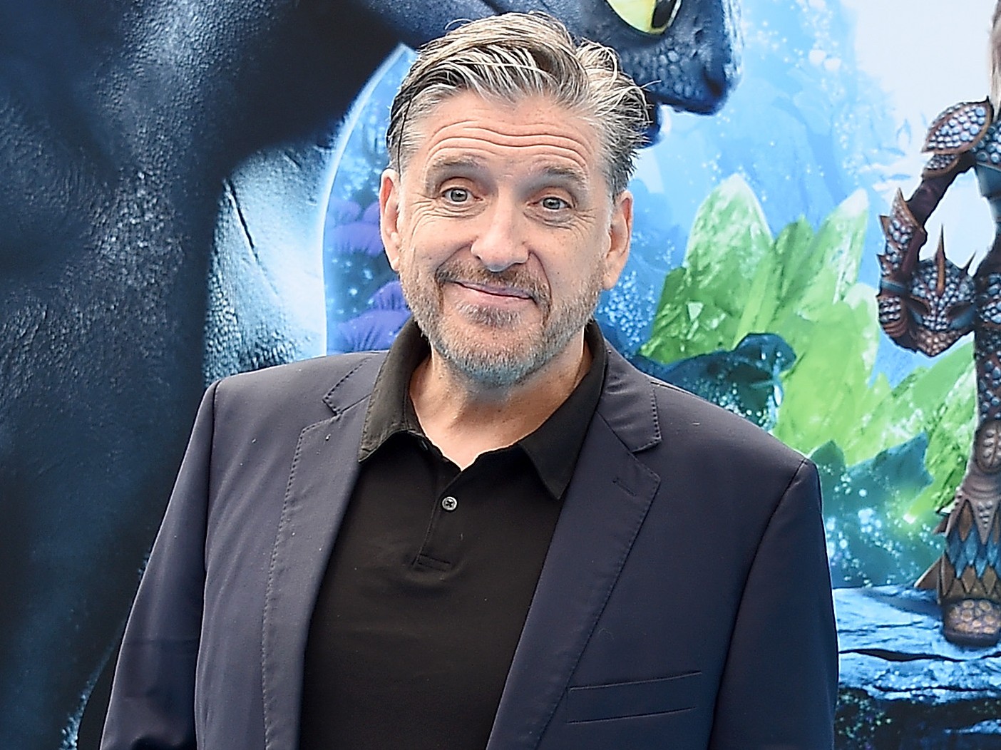 Craig Ferguson smiles wearing black dress shirt and charcoal gray blazer