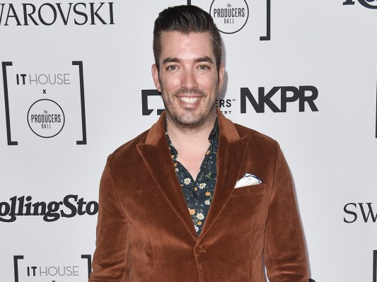 Jonathan Scott smiles while wearing a brown velvet blazer